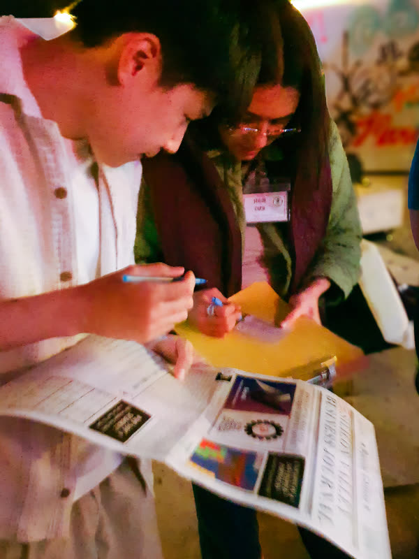 Two players examining a newspaper clue together